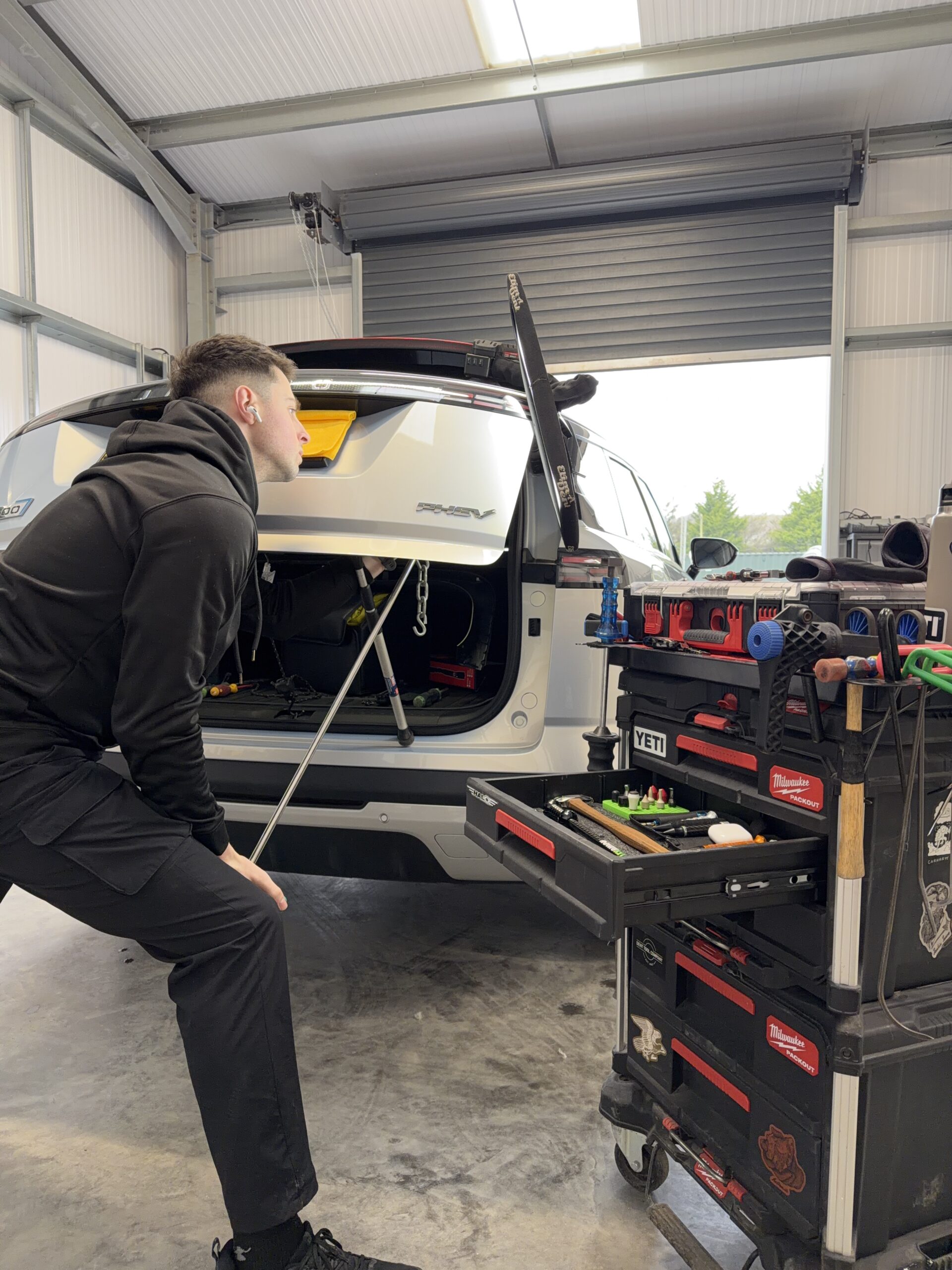 Paintless Dent Repair technician repairing a sharp dent in Neath Port Talbot workshop